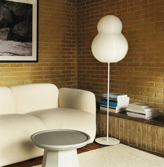 Veľká stojanová lampa z ryžového papiera pri dizajnovej sedačke v obývačke