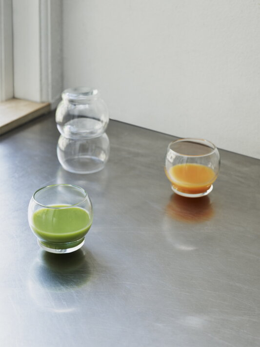 Číre poháre s oblým dnom so zeleným a oranžovým džúsom