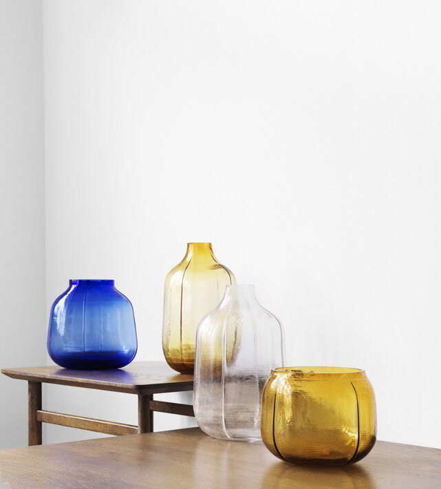 Dekoračné sklenené vázy s vrstveným dizajnom na drevených stolíkoch