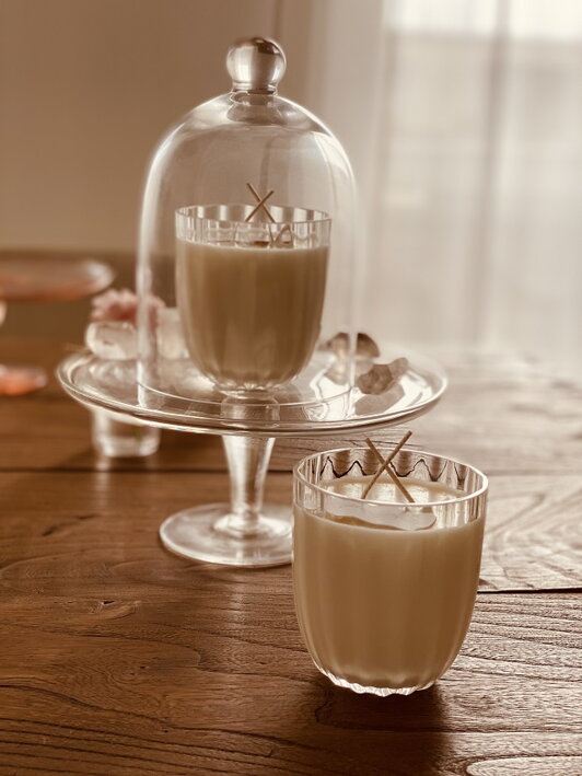 Malý číry krištáľový pohár v retro dizajne naplnený vegánskym voskom tvorí vonnú sviečku s vôňou jeseň na vidieku