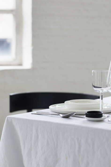 Rovný pohár na biele víno pri bielom riade na prestretom jedálenskom stole