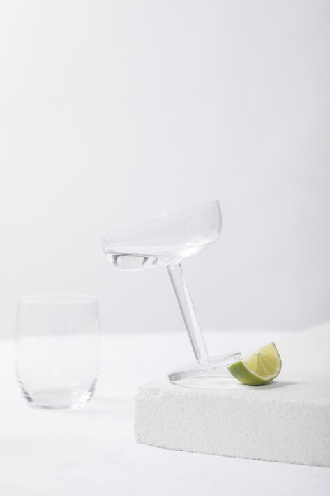 Široký pohár na šampanské z tvrdeného skla podopretý limetkou