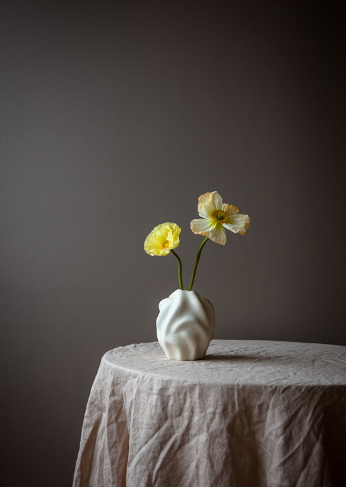 Nepravidelná keramická váza v krémovej farbe so žltými živými kvetmi