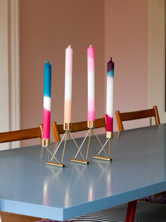 Mosadzný svietnik s farebnými sviečkami na jedálenskom stole