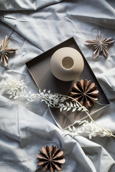 Hnedé papierové kvety ako sezónna dekorácia na podnose s vázou