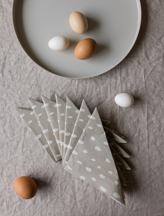 Pieskové servítky s motívom bodiek na stole pri podnose s vajíčkami