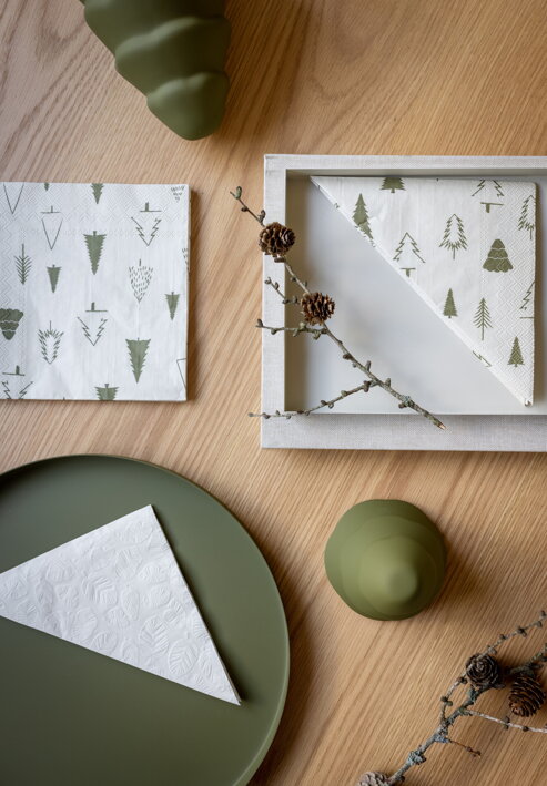 Krémové servítky so zelenými stromčekmi ako stolová dekorácia