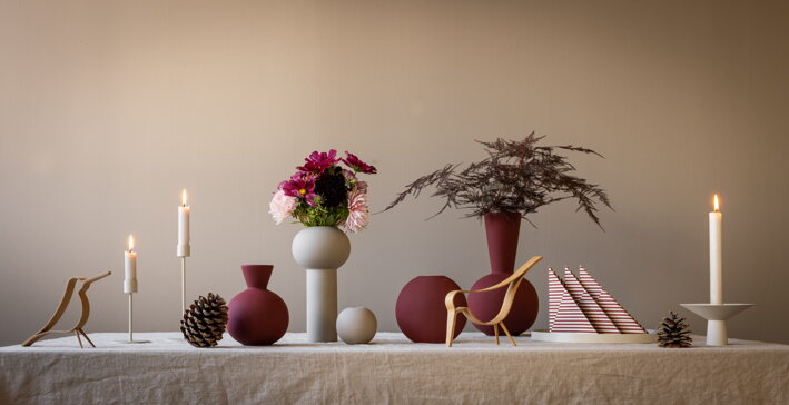 Biele servítky s červenými čiarami na prestretom stole s vázou