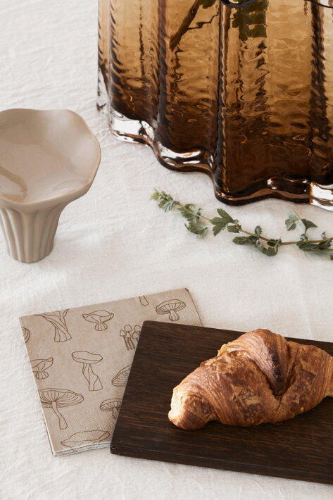 Dekoračná servítka s motívom hríbikov na stole s croissantom a vázou