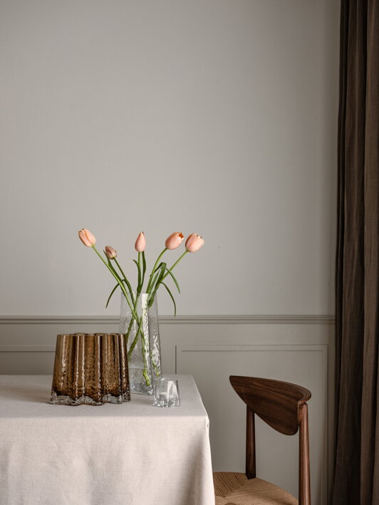 Veľká číra váza z ručne fúkaného skla s tulipánmi na stole