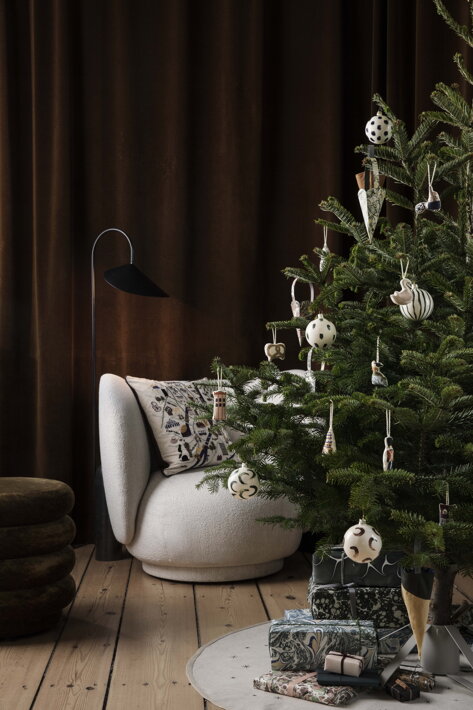 Okrúhla bavlnená podložka v pieskovej farbe pod minimalistickým vianočným stromčekom
