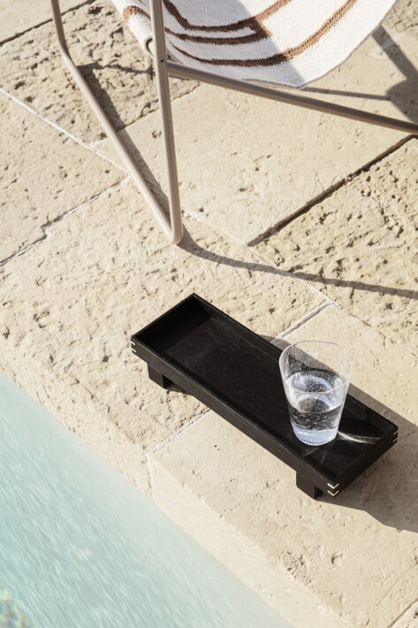 Čierny drevený podnos Bon s pohárom vody na terase pri bazéne