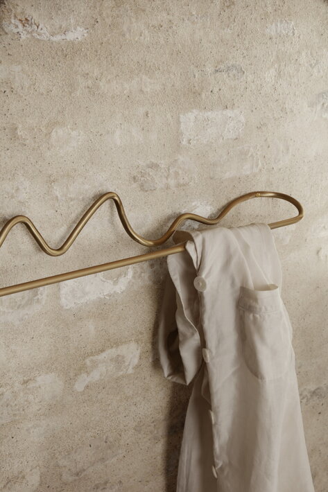 Dizajnový mosadzný vešiak na uteráky a oblečenie na tehlovej stene