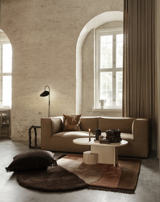Hnedý dekoratívny vankúš s detailnou výšivkou na pohovke v obývačke