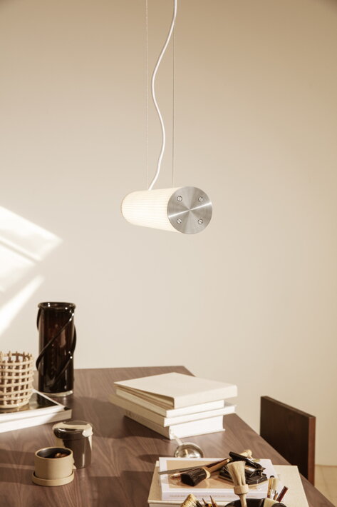 Dizajnová vrúbkovaná lampa visiaca nad kancelárskym stolom