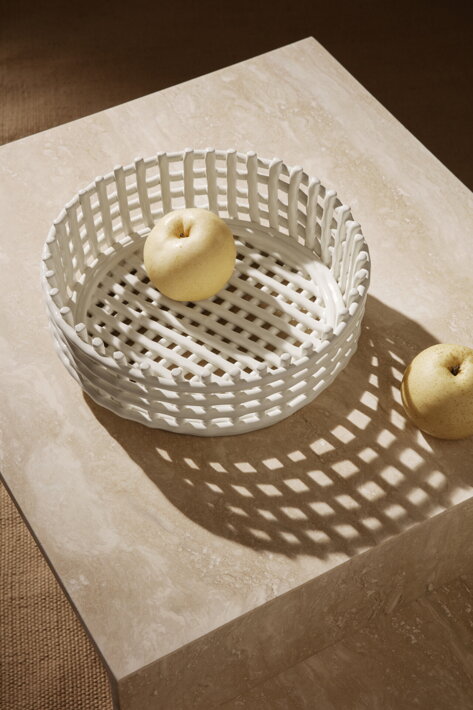 Biela ručne tvarovaná misa na ovocie s jablkami na travertínovom konferenčnom stolíku