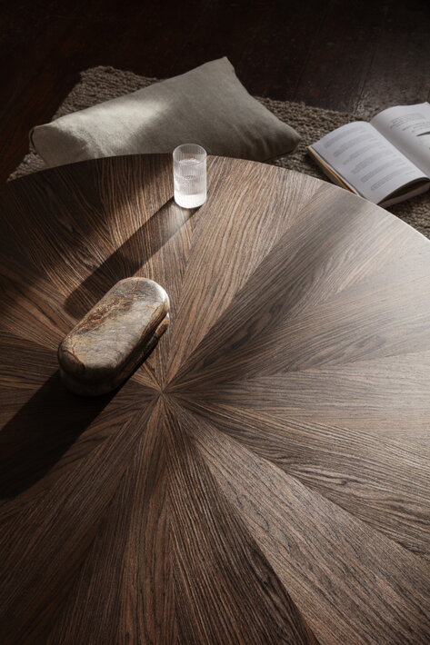 Veľký okrúhly dubový stolík s troma nohami v obývačke
