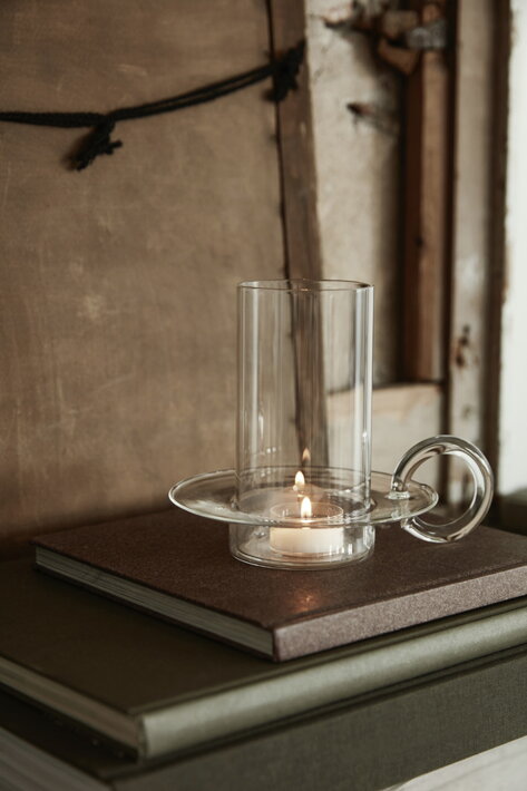 Dizajnový sklenený svietnik s rúčkou v obývačke