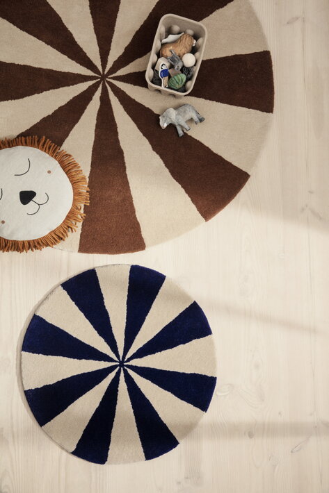 Malý okrúhly koberec v modrobielej kombinácii s plyšovým levíkom v detskej izbe