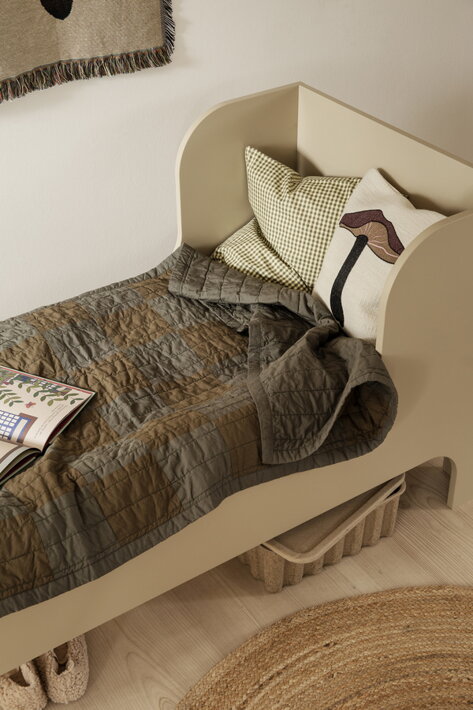 Milý vlnený vankúš s vyšívaným hríbikom na detskej posteli