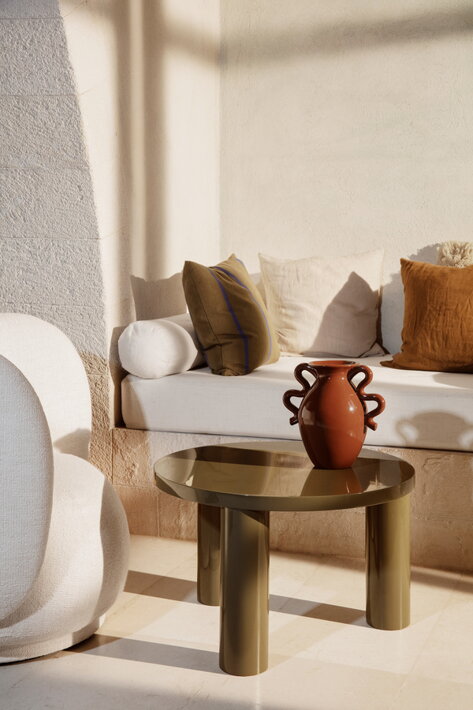 Lakovaný olivový okrúhly stolík s troma nohami v obývačke