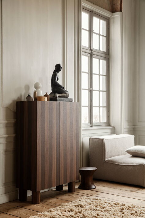 Dizajnový stolček z masívneho dreva pri štýlovej komode v obývačke
