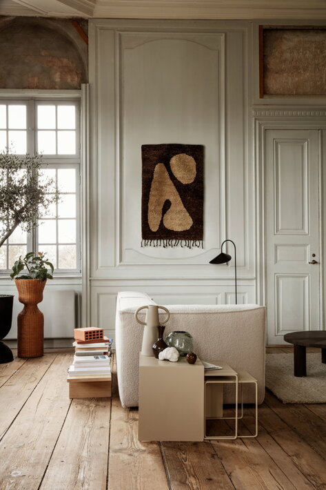 Vysoký ratanový kvetináč na drevenej podlahe v dizajnovej obývačke