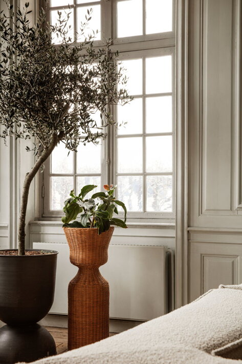Vysoký ratanový stojan na izbovú rastlinu pri okne v obývačke