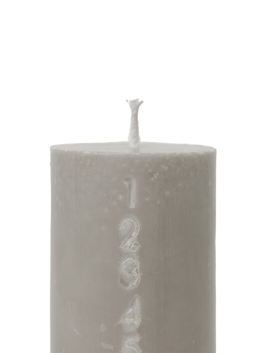 Hrubá sivá sviečka s vyrezávanými číslami ako adventný kalendár