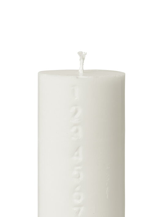 Hrubá biela sviečka s vyrezávanými číslami ako adventný kalendár