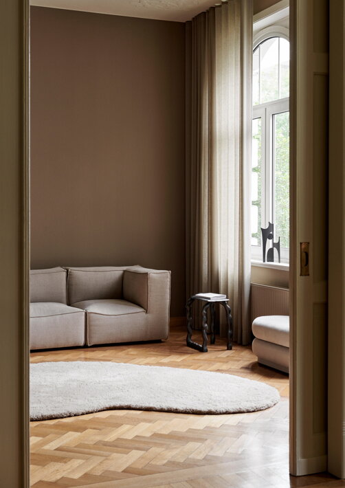 Béžový vlnený koberec v organickom tvare na parketách v obývačke