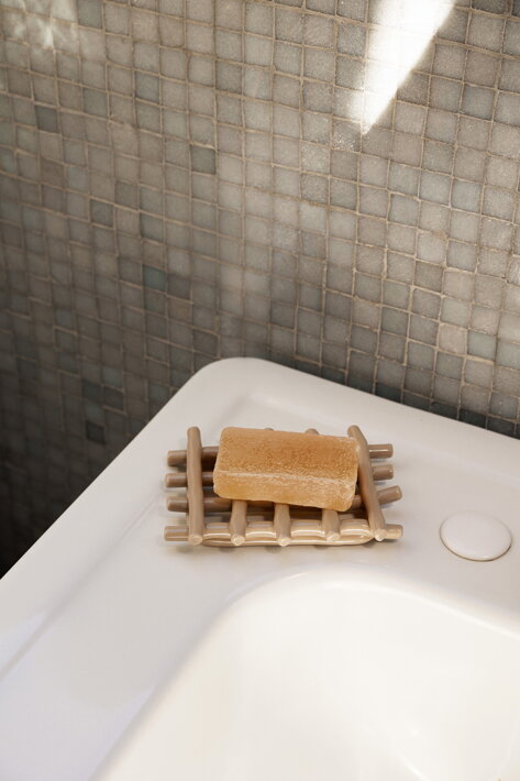 Ručne pletená keramická mydelnička v kašmírovej farbe na umývadle v kúpeľni