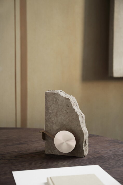 Dizajnový držiak na lepiacu pásku z travertínového kameňa a mosadze na stole v pracovni