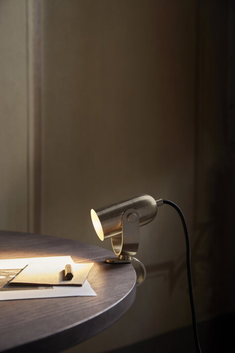 Minimalistická mosadzná lampička s držiakom na okraji pracovného stola