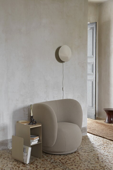 Dizajnový kovový stolík s bielym mramorom pri štýlovom kresle v obývačke