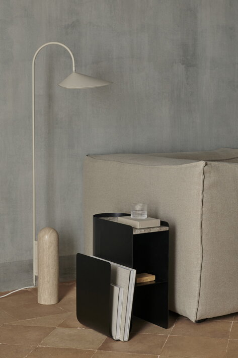 Dizajnový kovový stolík s čiernym mramorom pri dizajnovej lampe v obývačke