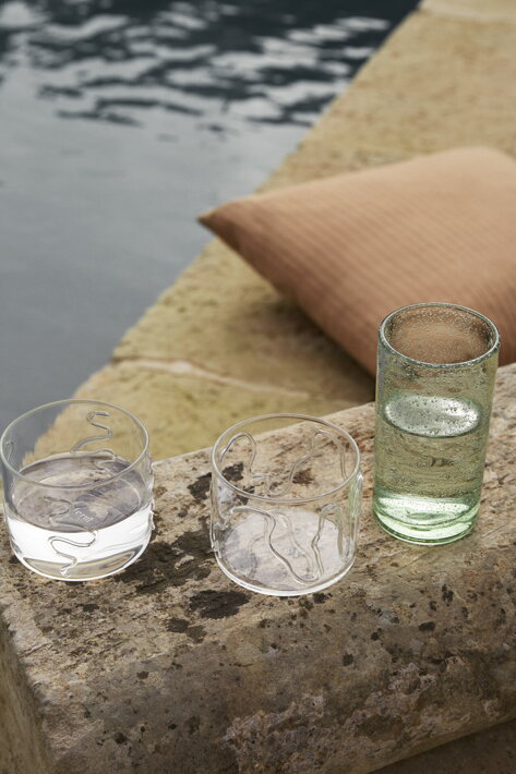 Umelecky zdobené nízke poháre z číreho skla pri bazéne