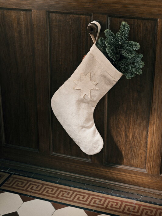Ponožka z bavlny na vianočné darčeky zavesená na krbe