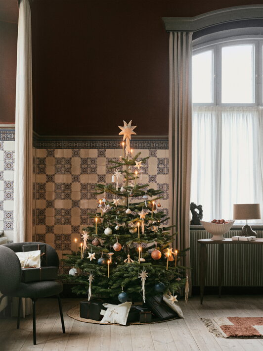 Textilná hviezda ako špic na vyzdobenom vianočnom stromčeku