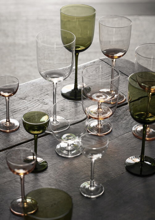 Stopkové zelené poháriky na alkohol na stole s jedlom