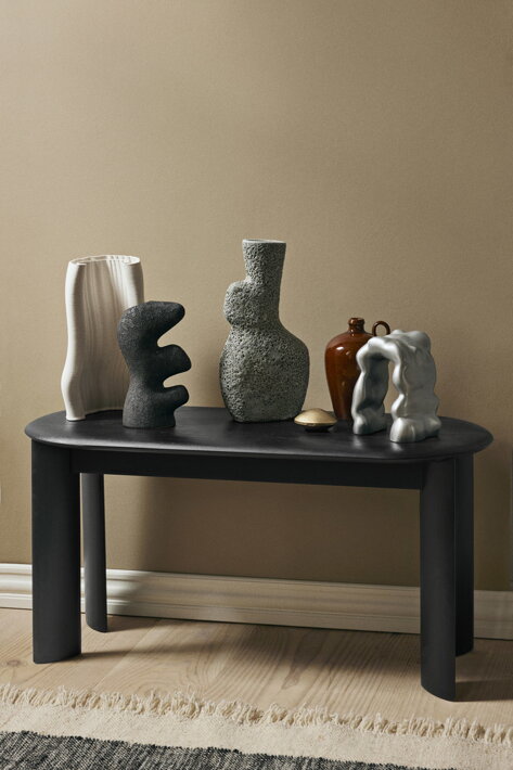 Váza z keramiky s reaktívnou glazúrou na stolíku medzi dizajnovými vázami