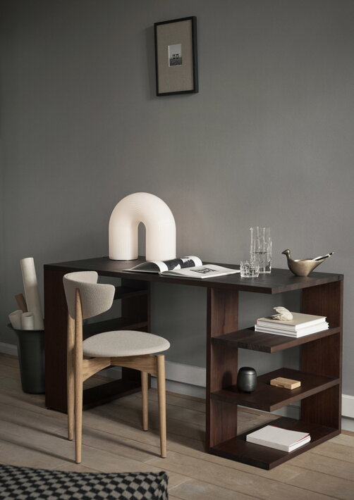 Masívny drevený stôl v tmavohnedej farbe s dizajnovou stoličkou a časopismi