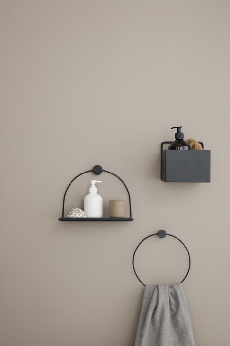 Čierny okrúhly vešiak na uteráky s dreveným prvkom na stene pri nástennej poličke a úložnom boxe