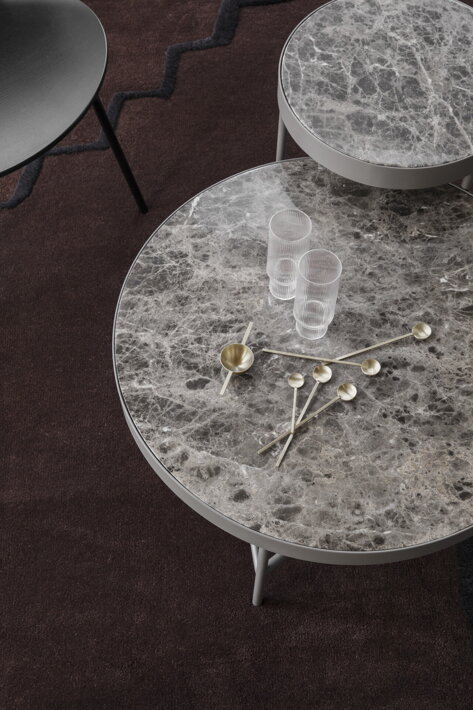 Dlhé a krátke mosadzné lyžičky Fein na mramorovom stole pri vysokých pohároch Ripple