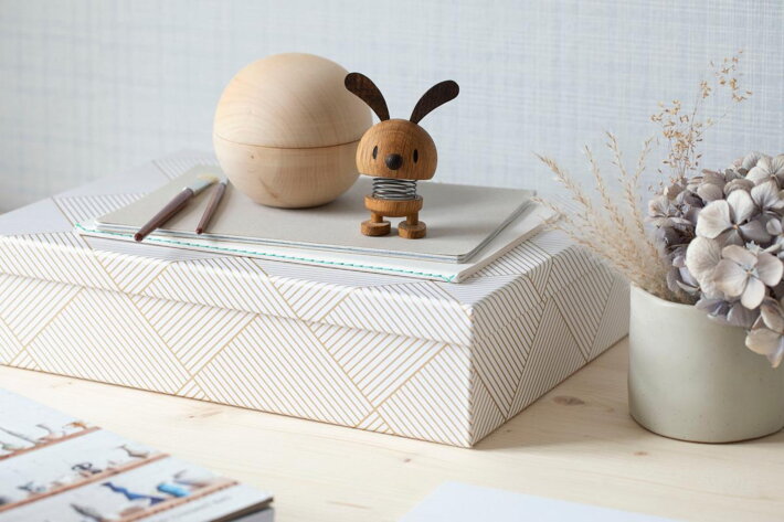 Veselý zajačik z dubového dreva na pružine na pracovnom stole v kancelárii