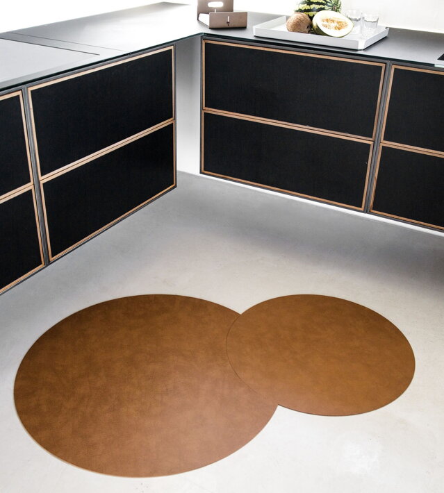 Dizajnový koberec z recyklovanej kože na bielej dlažbe v kuchyni