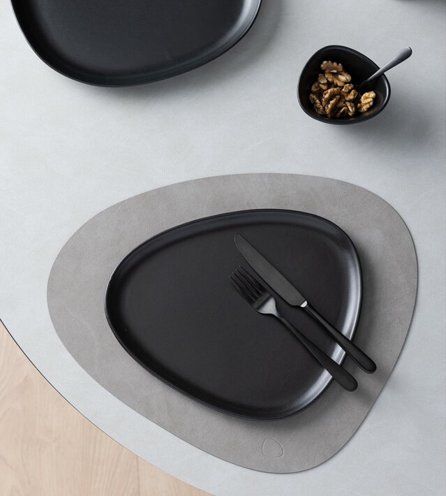 Elegantný veľký tanier z čiernej kameniny na koženom prestieraní