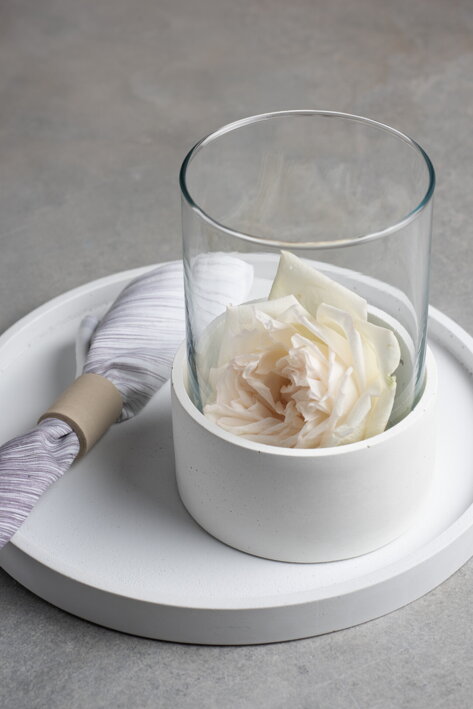 Biela betónová váza so sklenenou vložkou na okrúhlom podnose