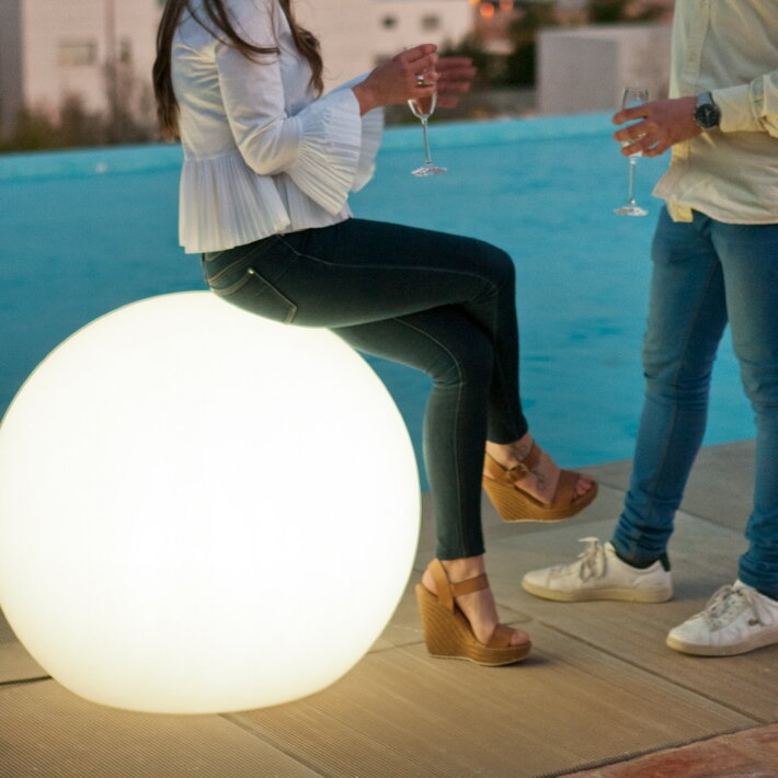 Veľká záhradná svetelná guľa ako posedenie na letnej párty
