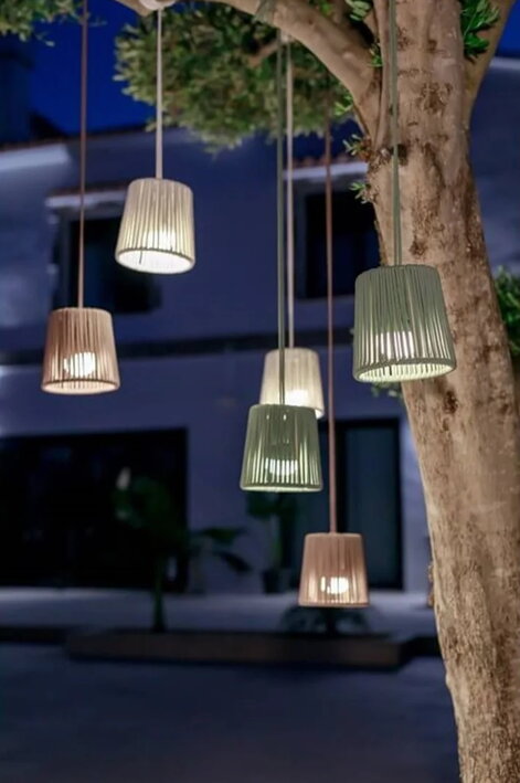Malé závesné lampy Conta Mini svietiace na konároch stromu vo večernej atmosfére